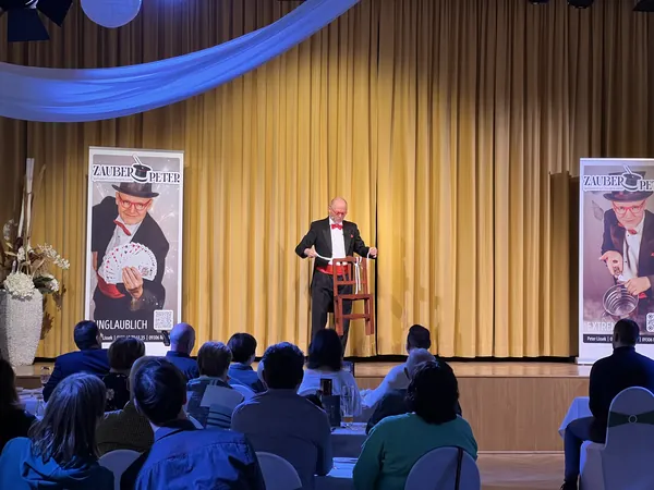 Zauberer Peter Lissek auf der Bühne vor vollem Saal im Bürgerhaus Rochlitz